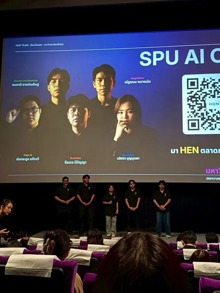 Our team on stage in front of the 'Our team' slide, where Thanachart is listed as System Architecture